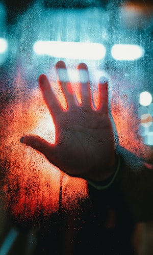 Hand up against a misty window