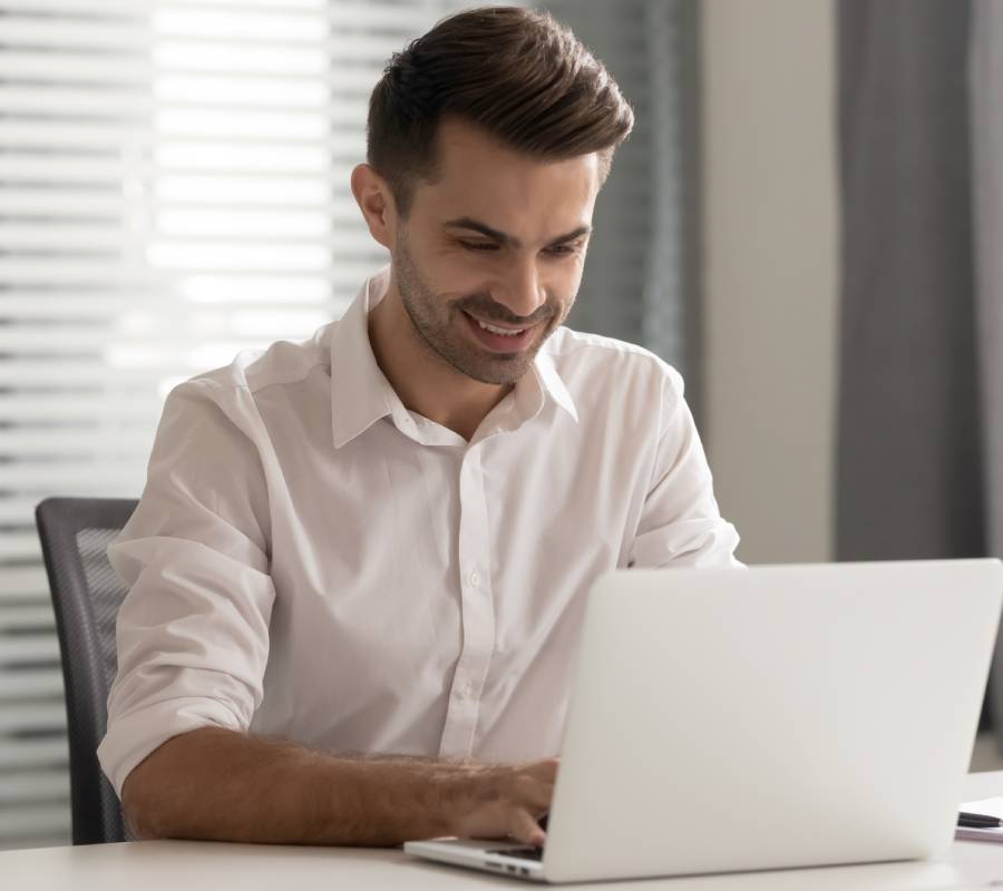 A man smiling using a laptop